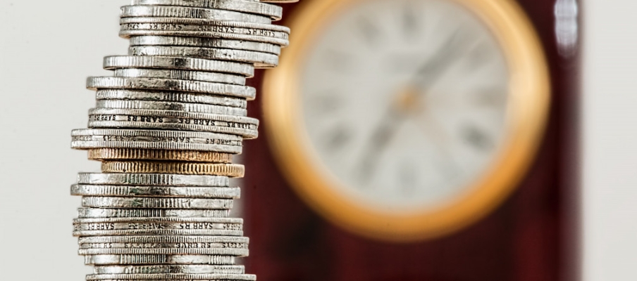 Coins stacked up against a clock